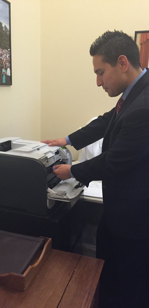 Jonathan servicing an office printer on site for a client
